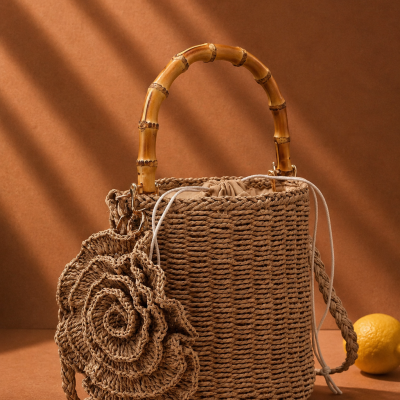 Mala de mão trançada orgânica com alça de bambu e detalhe floral