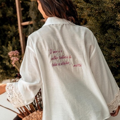 Camisa branca com bordado e renda, vista de costas em ambiente exterior