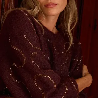 Pullover castanho escuro com fios dourados usado por mulher