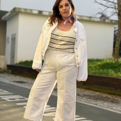 Mulher com roupas brancas e ténis rosa ao ar livre