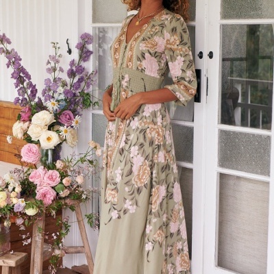 Vestido longo floral verde e rosa com cinto franzido em mulher na varanda com flores