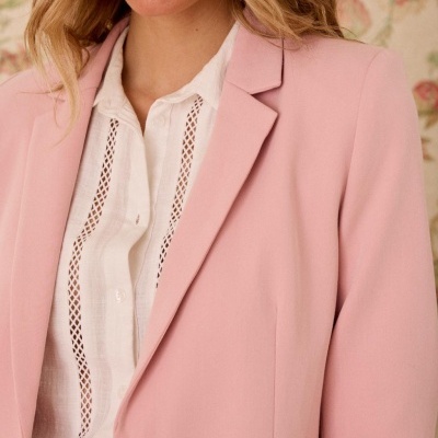 Casaco rosa com botão e camisa branca com rendas verticais