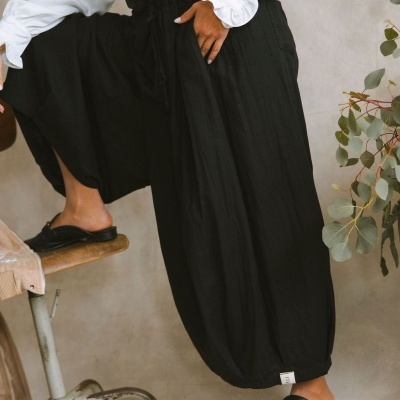 Calças largas pretas com elástico na cintura e punhos ajustados