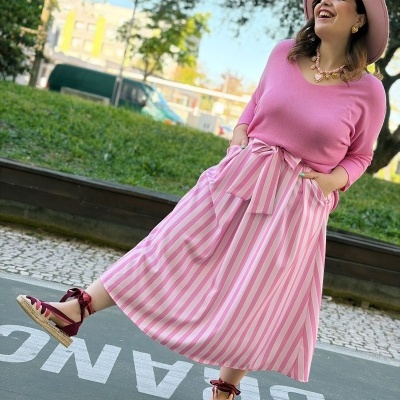 Mulher com roupa rosa e acessórios em ambiente exterior