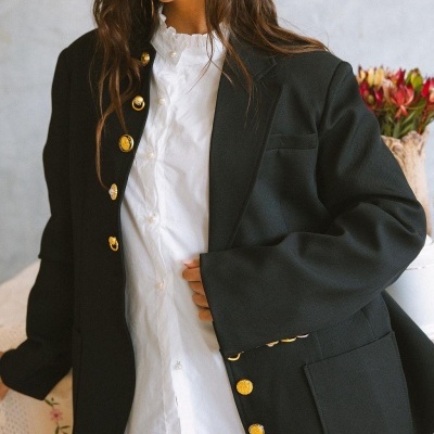 Blazer preto com botões dourados e camisa branca com gola franzida