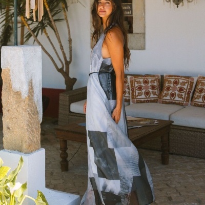 Vestido comprido cinzento e preto com padrão abstracto usado por mulher em ambiente exterior