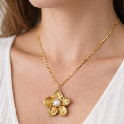 Colar dourado com flor e pérola ao pescoço