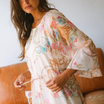 Vestido feminino branco com padrão floral colorido e mangas largas