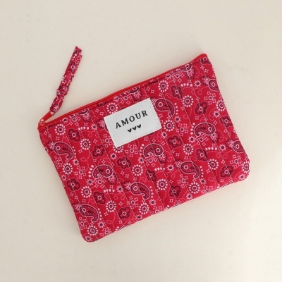 Bolsa vermelha com padrão paisley e etiqueta AMOUR