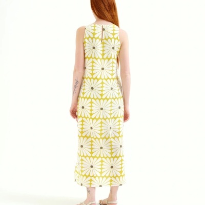Vestido comprido amarelo com padrão de flores brancas grandes e sandálias brancas simples