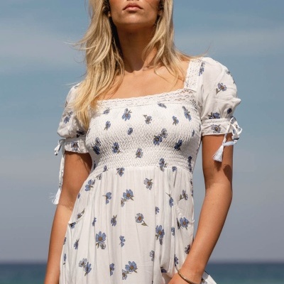 Vestido branco com padrão floral azul e manga curta com laços