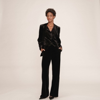 Conjunto feminino preto de veludo com blazer e calças em fundo claro