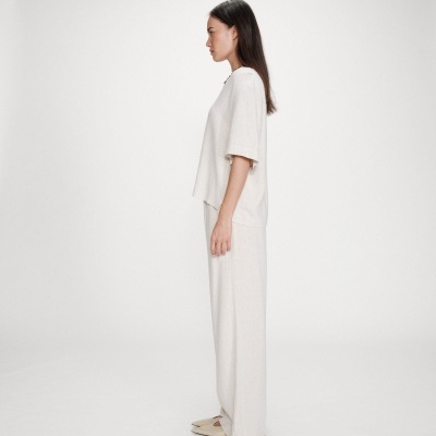 Conjunto feminino bege com t-shirt e calças largas, sapatos baixos de bico fino