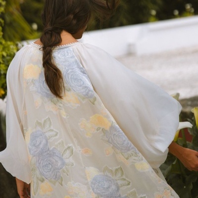 Vestido branco com flores bordadas visto de costas