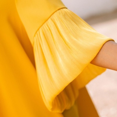 Detalhe de manga de vestido amarelo com plissado e marca maittè