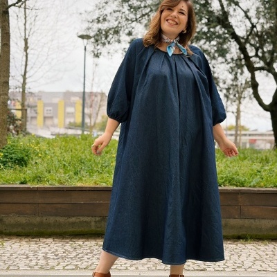 Mulher com vestido maxi azul escuro e sandálias castanhas ao ar livre