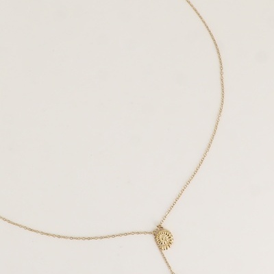 Colar dourado com dois pendentes, um redondo e outro em forma de concha