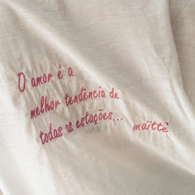 Tecido creme com bordado rosa com frase e logótipo maitè