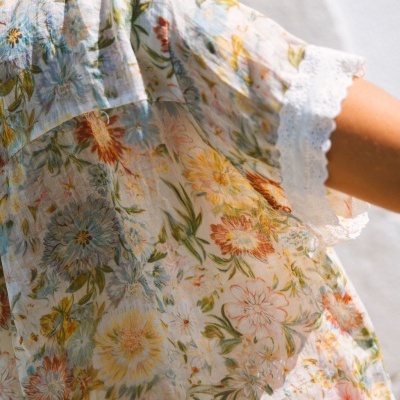 Blusa feminina com padrão floral e renda na manga