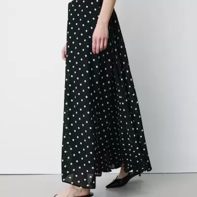 Saia preta comprida com bolinhas brancas e sapatos pretos de salto baixo