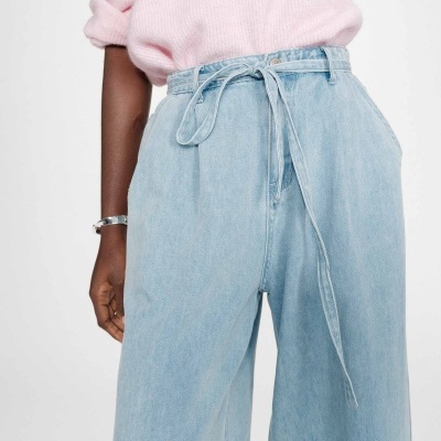 Calças de ganga largas azuis claras com cinto fino e nó