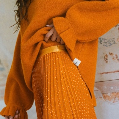 Camisola ferrugem de malha com saia plissada laranja e pontos brancos