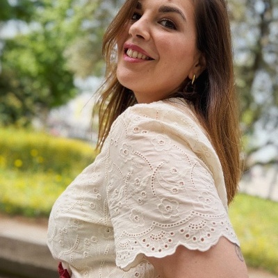 Mulher a usar blusa branca bordada com padrão floral ao ar livre
