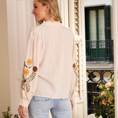 Blusa creme com bordados nas mangas e jeans azuis claros