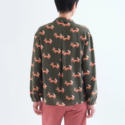 Camisa verde-escura com padrão de cães cor de rosa e calças cor de rosa vista de costas