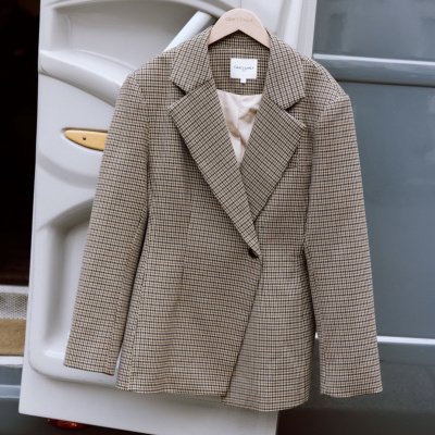 Blazer castanho às riscas em cabide pendurado numa porta de veículo branco.