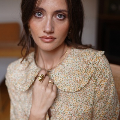 Blusa feminina floral com gola grande e joias douradas