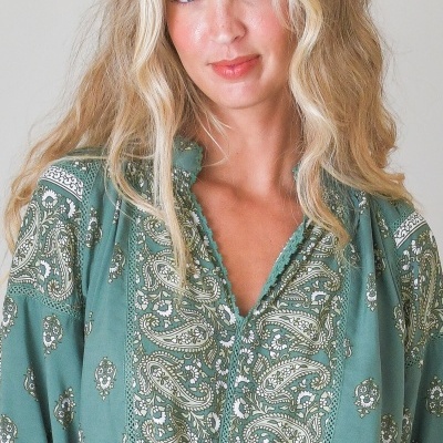 Blusa verde com padrão floral e cachemira e detalhes de renda no decote.