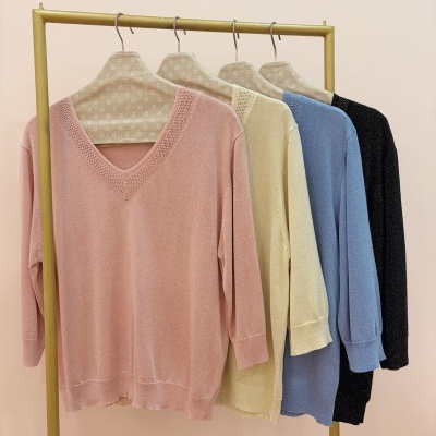 Camisolas de tricot em várias cores penduradas em cabides com padrão de estrelas