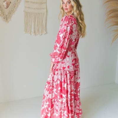 Vestido comprido com padrão floral vermelho e branco em ambiente minimalista com decoração de macramé