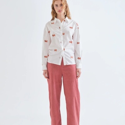 Camisa branca com padrão de cães castanhos e calças rosa caneladas