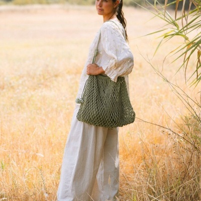 Mulher com saco de malha verde em campo ao ar livre