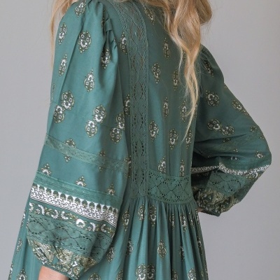 Vestido verde com padrão e renda detalhada nas mangas e costas