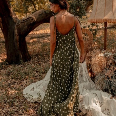 Vestido comprido verde com bolinhas brancas usado por mulher numa floresta