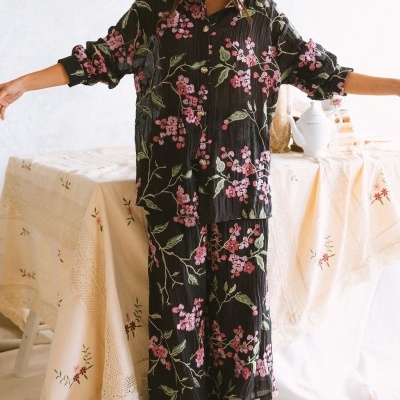 Conjunto de pijama floral preto com camisa e calças largas, usado com botas marrons.