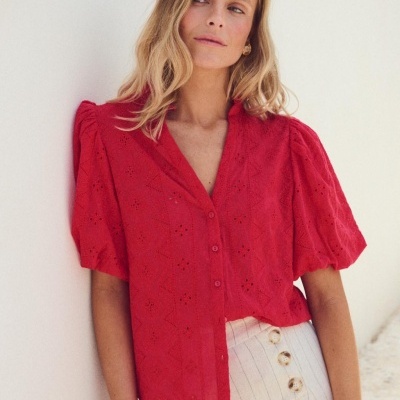 Blusa vermelha bordada com mangas curtas e saia clara com riscas e botões