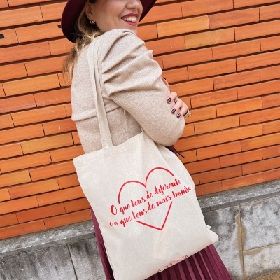 Mala de tecido bege com estampa de coração e texto vermelho