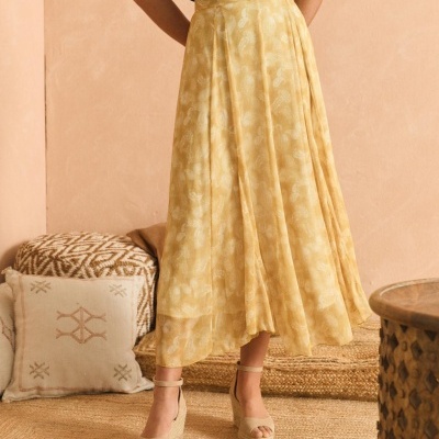 Saia midi amarela com padrão floral e sandálias bege com cunha