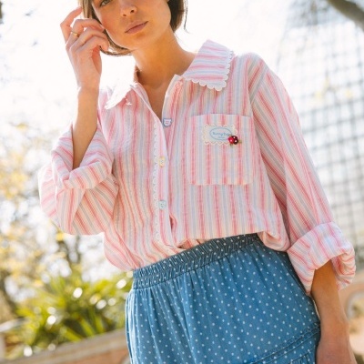 Camisa feminina de riscas coloridas com bolso e saia azul de bolinhas