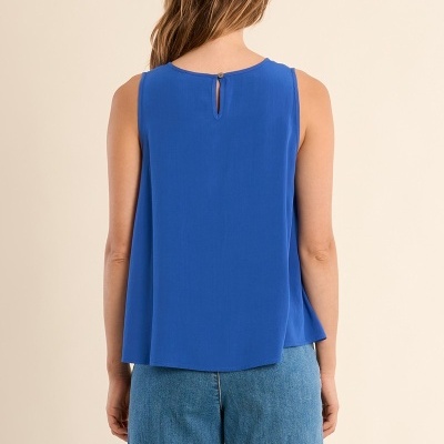 Blusa azul sem mangas vista de costas com botão no pescoço e calças de ganga