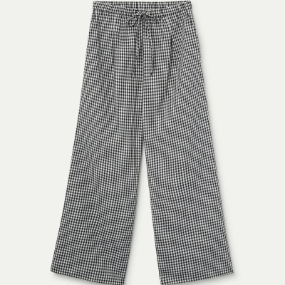 Calças largas com padrão xadrez preto e branco e cintura elástica com cordão.