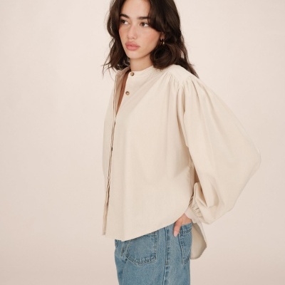 Blusa bege de manga comprida e bufante com jeans azul claro