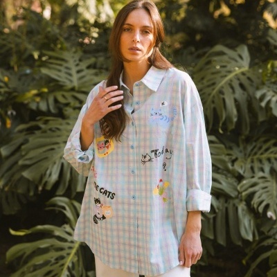 Camisa de algodão xadrez pastel com estampas de gatos e textos, e botões azuis