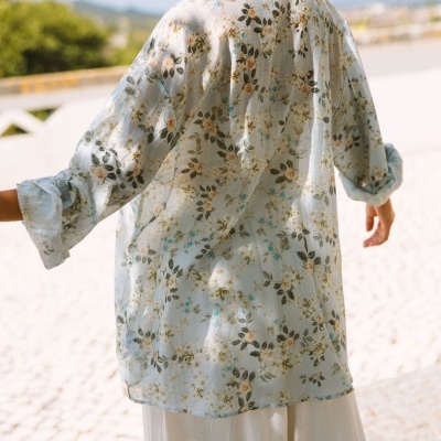 Camisa floral feminina transparente com calças brancas em exterior