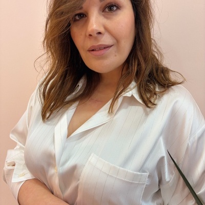 Mulher com camisa branca com riscas finas verticais e anéis dourados