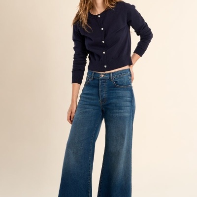 Mulher com camisola azul escuro e calças de ganga largas